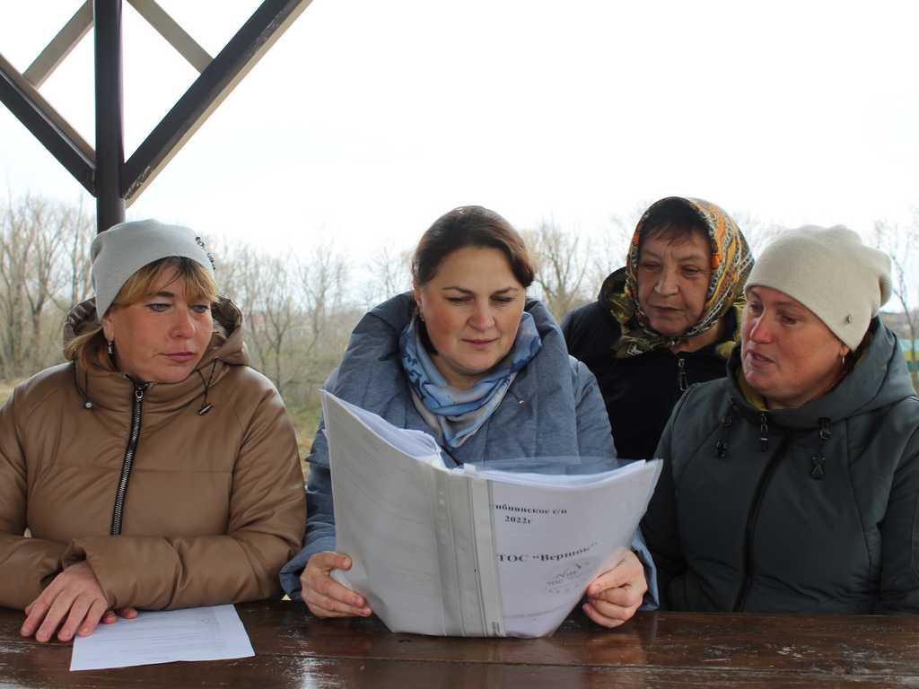 Наталья Емельянова (с папкой) обсуждает планы ТОСа с односельчанками
