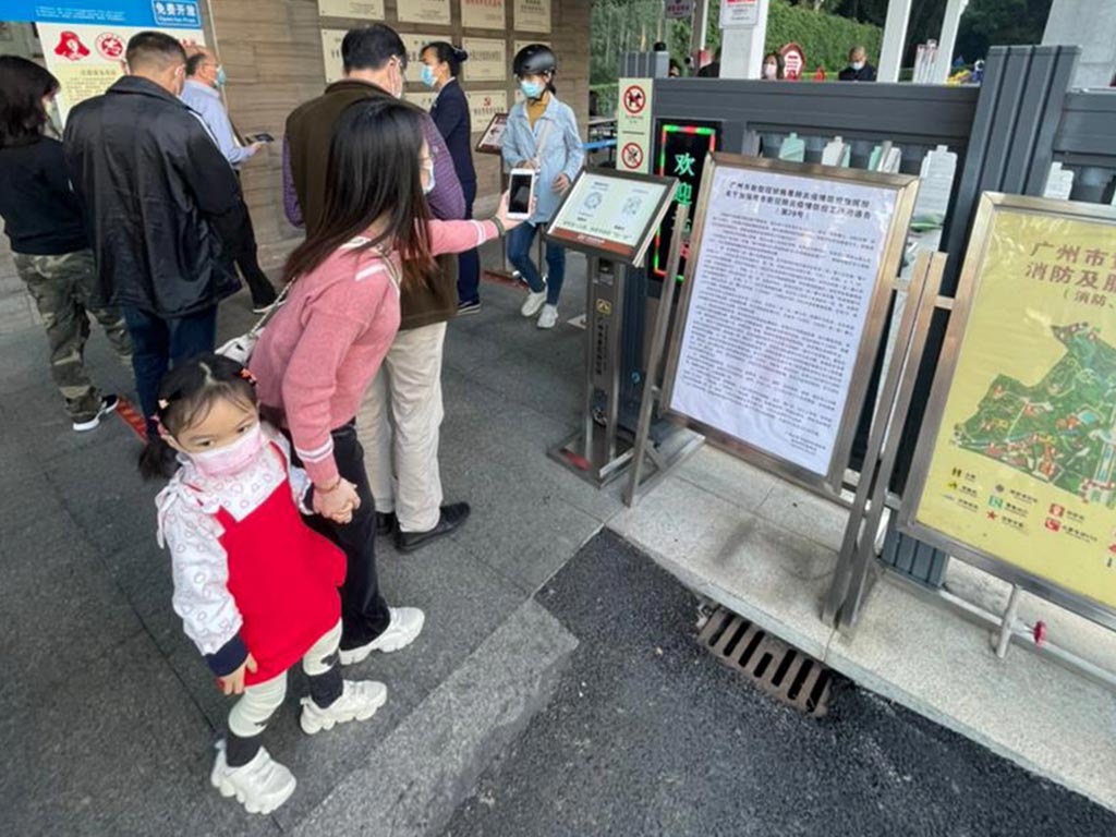 Китаянка сканирует код на входе в парк